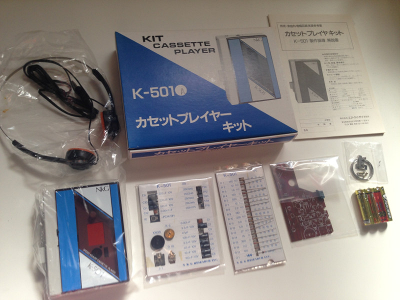 カセットプレイヤーキット K-501の付属品一覧。箱、本体、説明書、電子部品、ヘッドホン、半田、ネジ、金具、単三電池